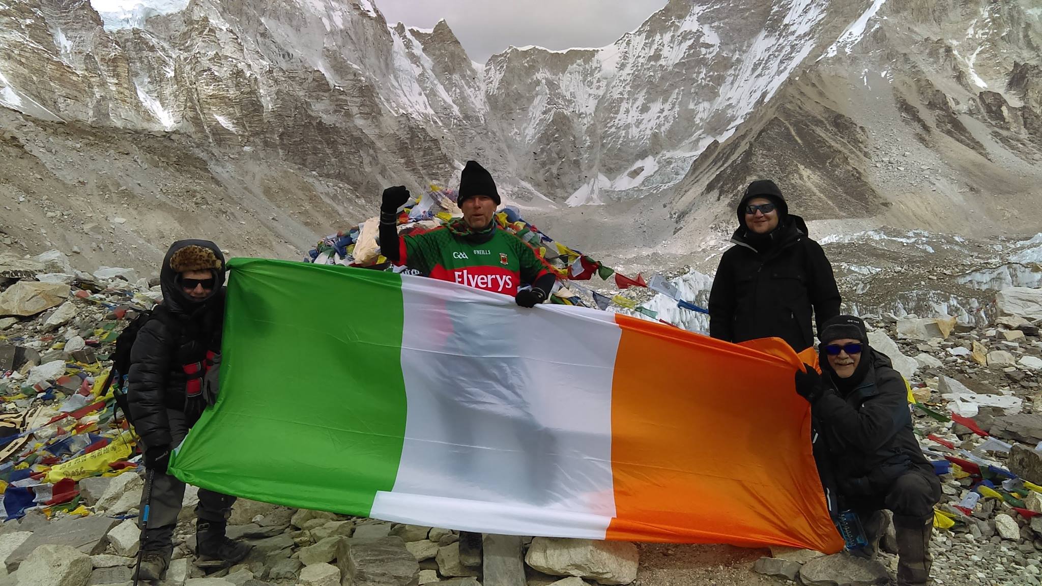 Trekkers holding an Irish flag on a mountain
