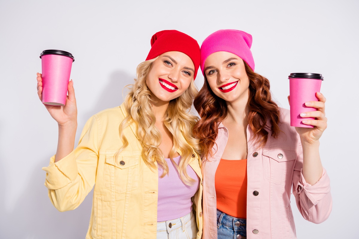 Two women holding pink coffee mugs