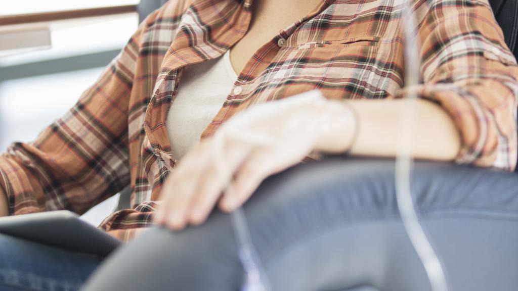 A young woman with short hair sitting in a chair with an infusion tube in her hand