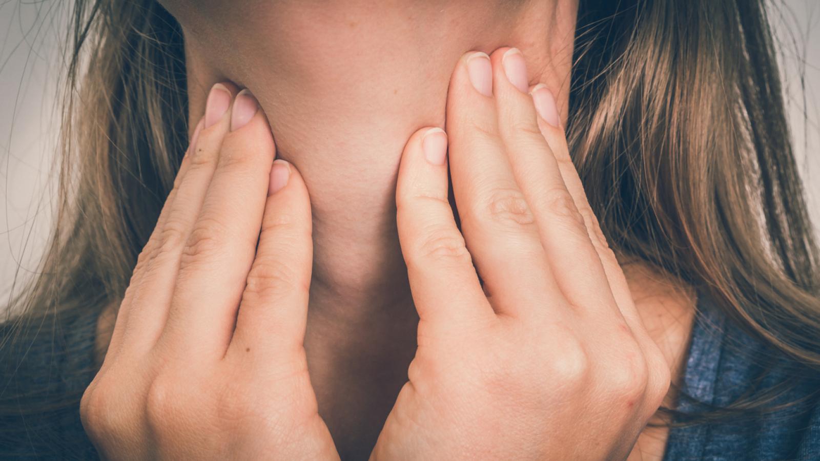 Woman holding her throat
