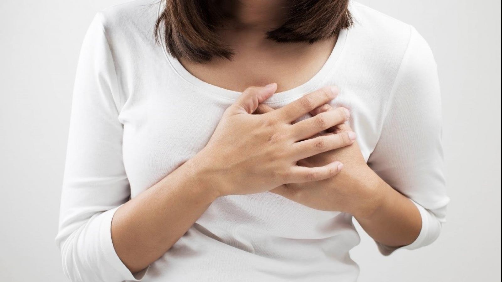 Woman holding her breast in pain
