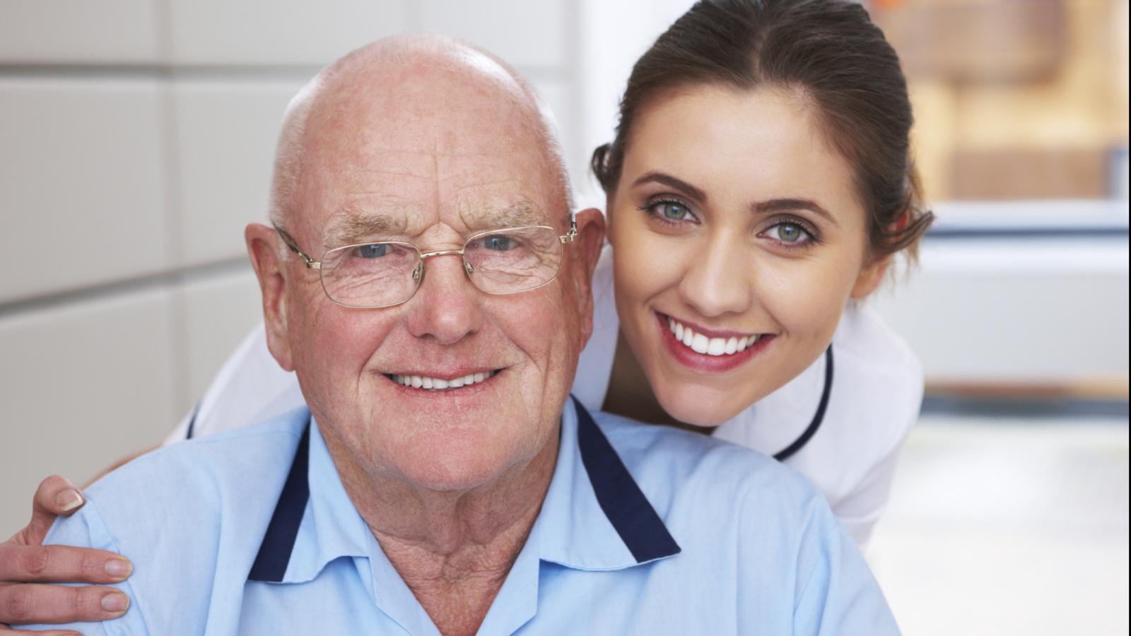 Older man and young female doctor smiling