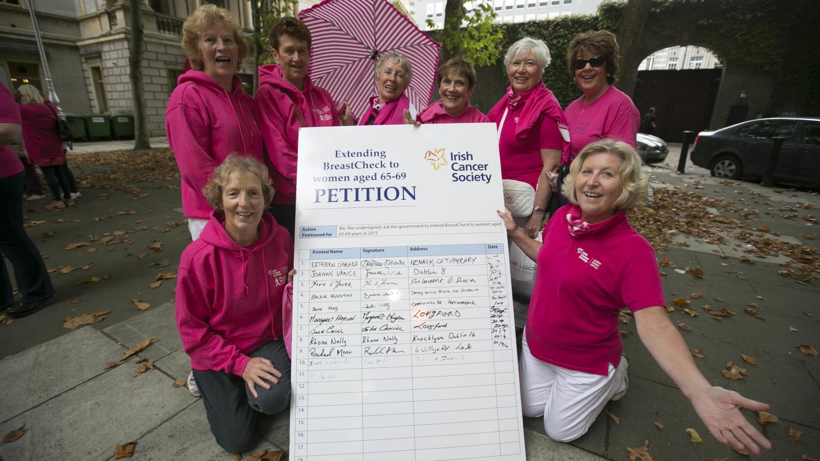 Advocacy volunteers standing beside a big petition