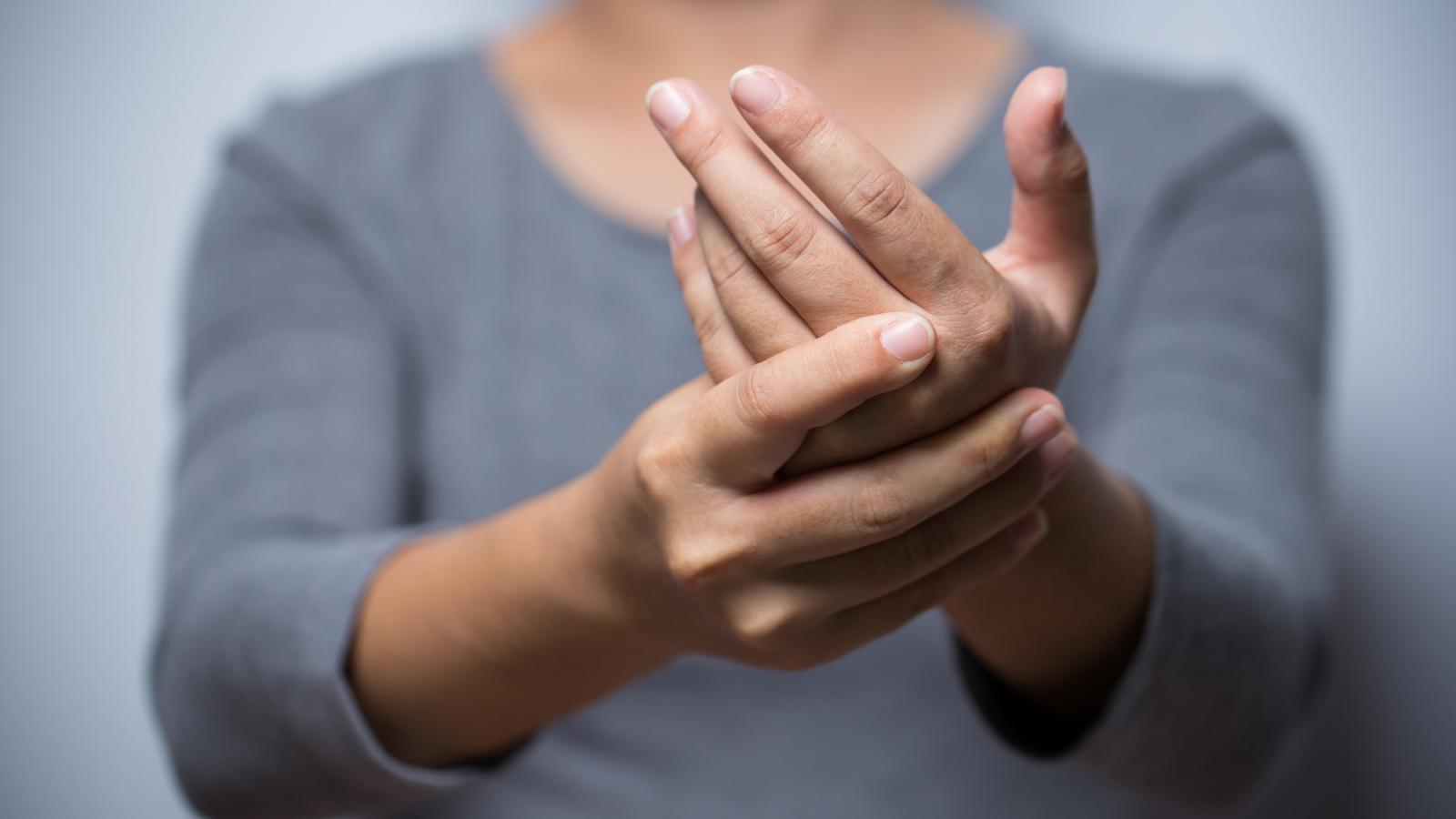 Woman experiencing pain and numbness in her hand