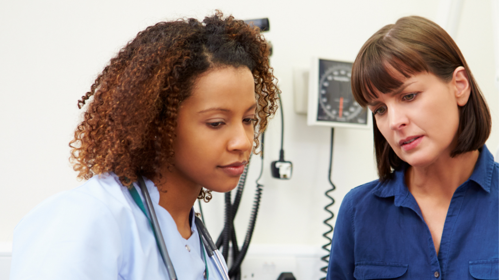 black female nurse explaining to white female patient