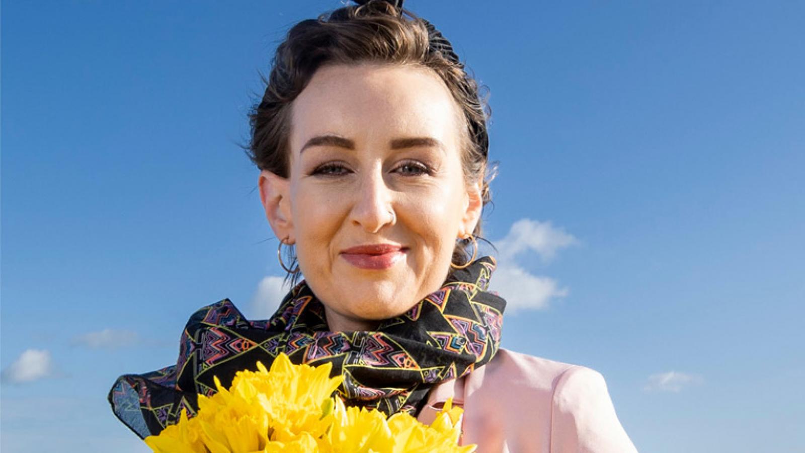 Donna-Marie Cullen on the beach holding daffodils
